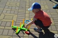Chłopczyk bawi się na placu trenując celność.